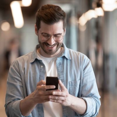 smiling-male-employee-using-modern-smartphone-texting